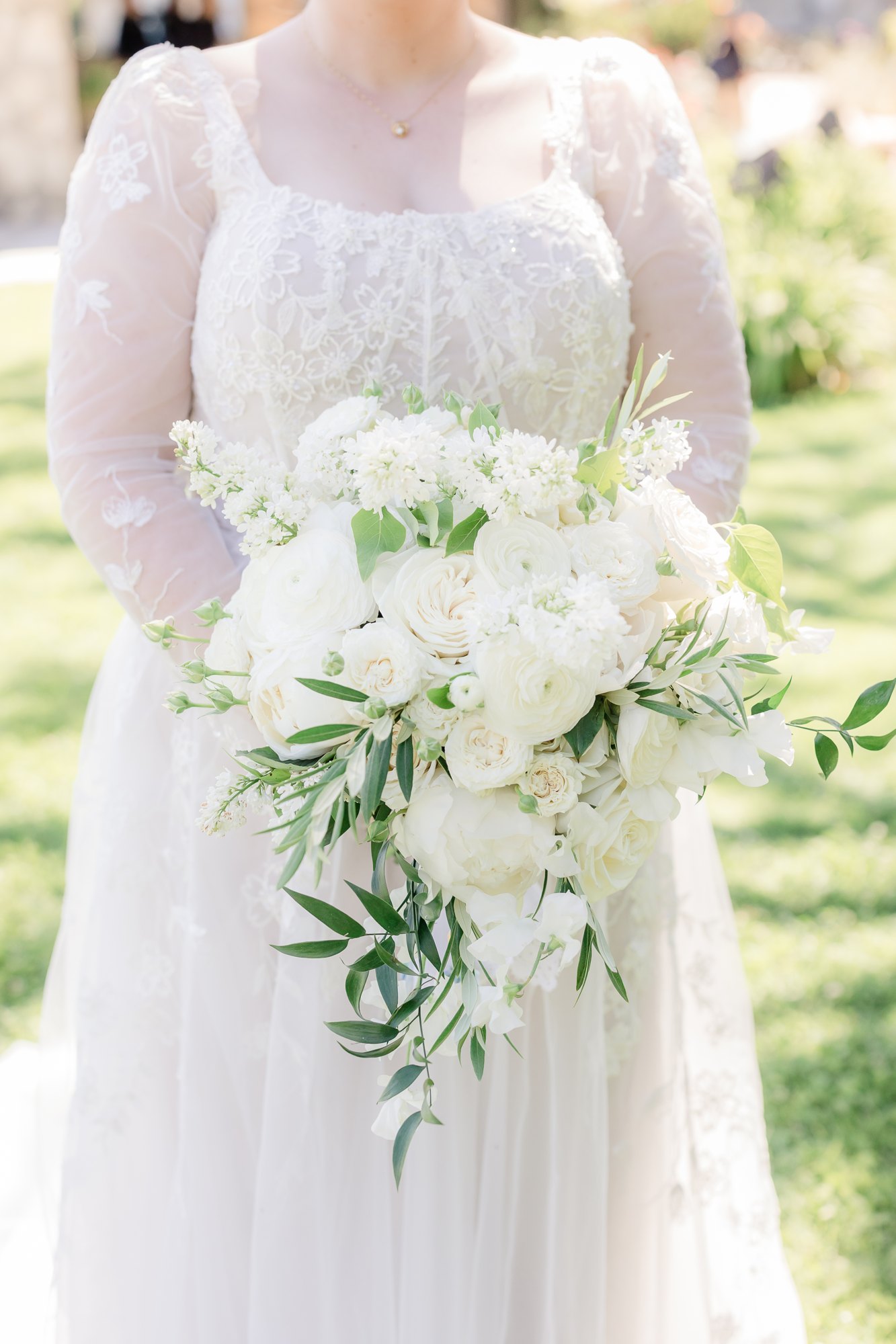 Bride holding a lush white-and-greenery bridal bouquet