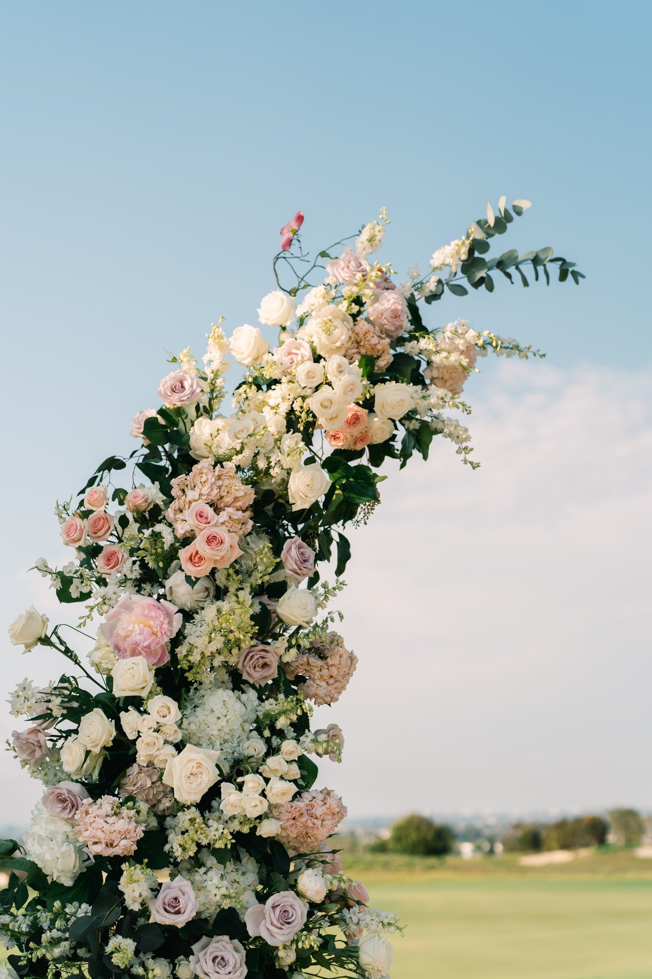 Blush and peach floral ceremony arch installation