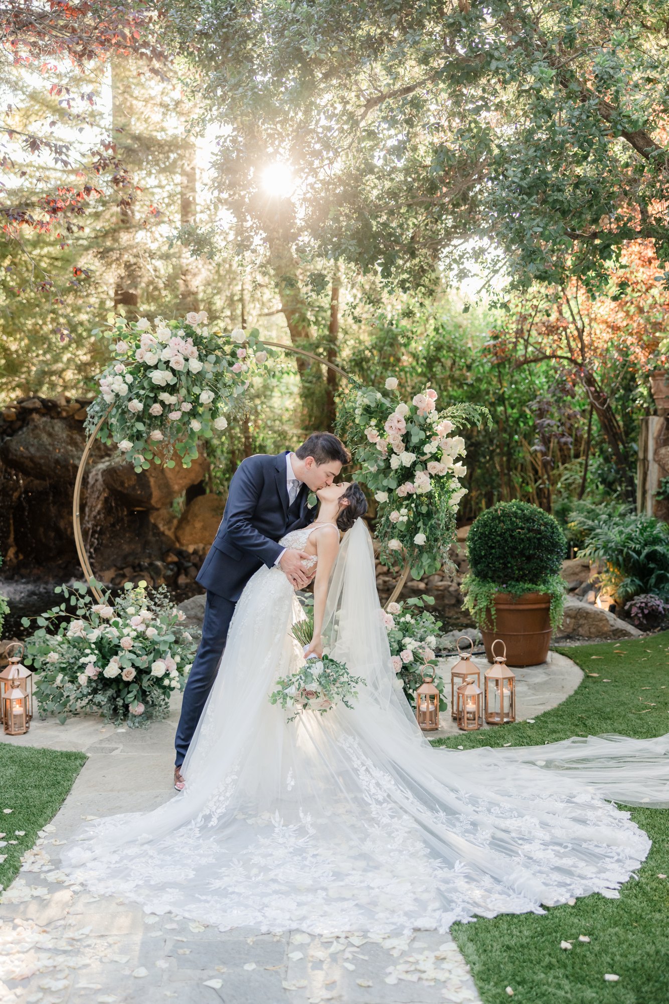 Bride and groom embracing in a garden with her bouquet