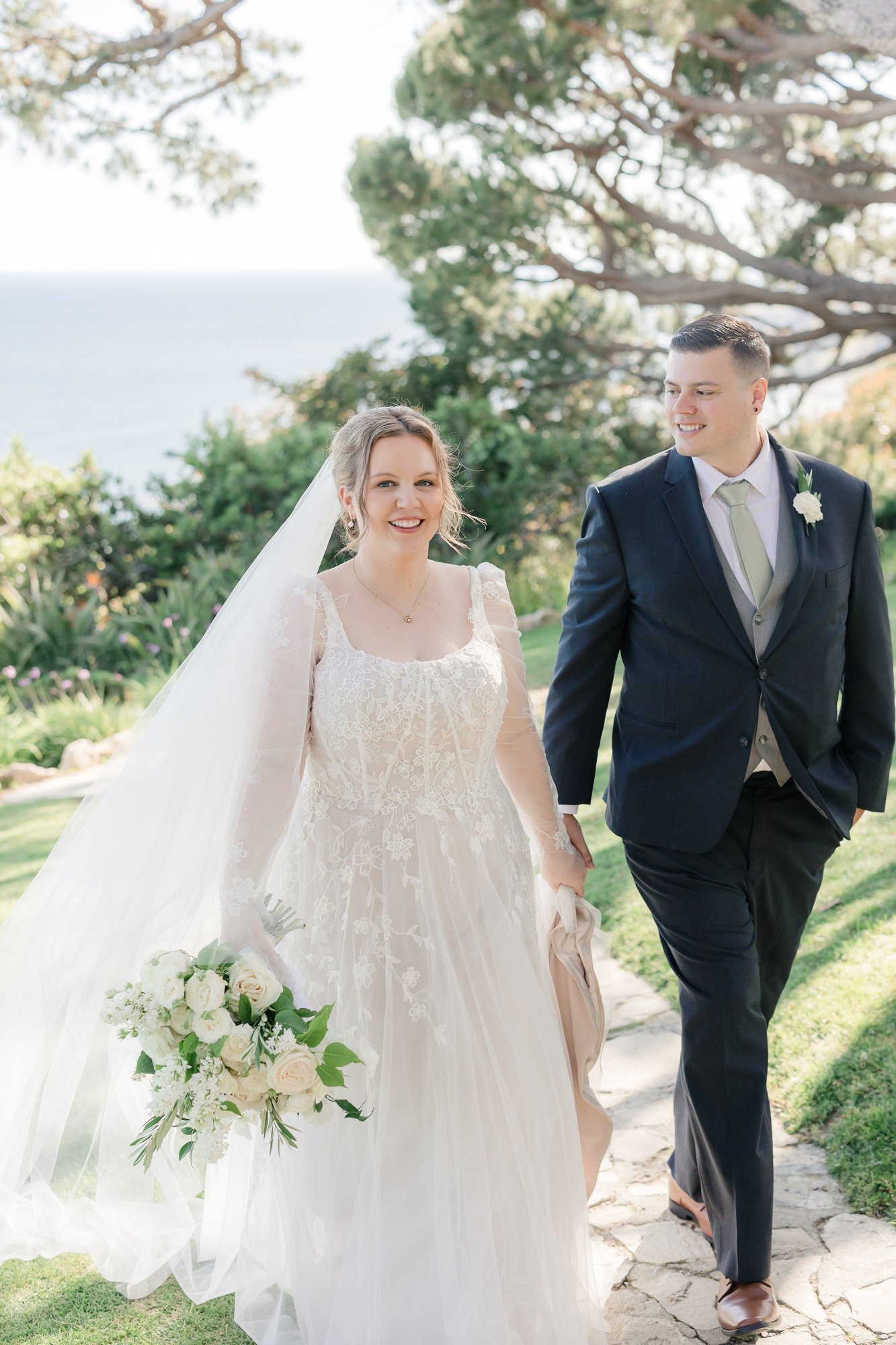 Couple walking together, bride holding a cascading bouquet